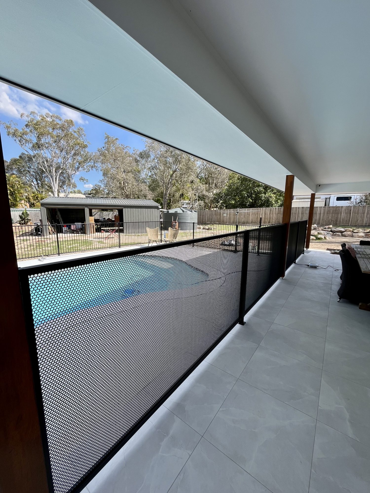Black Pool Perf architectural fencing beside a covered residential swimming pool